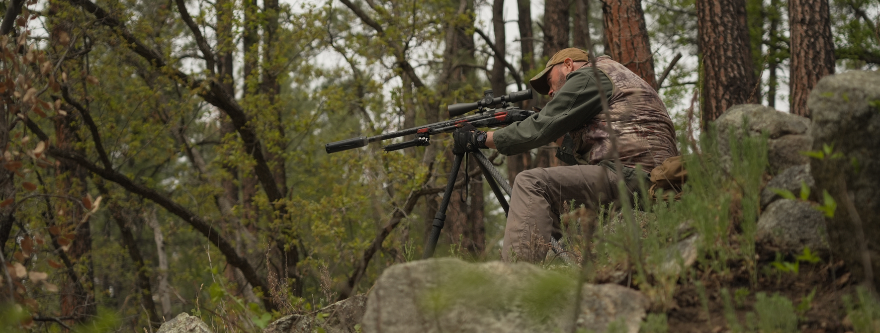 Sean Utley with Benchmark tripod and rifle in the forest